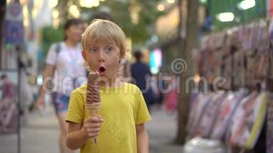 小男孩参观传统的韩国街头市场。 男孩正在吃一个33厘米长的冰淇淋。 前往韩国